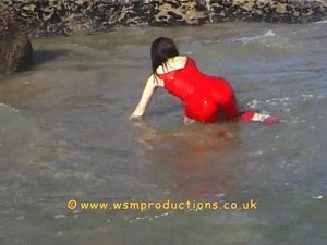 Jade in the surf in red silk pyjamas and heels